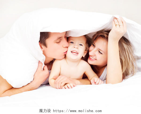 幸福温馨床上盖着被的一家三口父亲母亲孩子开心的玩欧美人物图